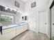 Bathroom with long vanity, double sinks, decorative mirror, and gray tile flooring at 7518 Mediterranean Ct, Hudson, FL 34667