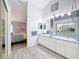 Bathroom with double sinks, gray tile flooring, and entrance to the bedroom at 7518 Mediterranean Ct, Hudson, FL 34667