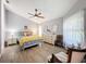 Comfortable bedroom with wood-look floors, ceiling fan, dresser, and two chairs at 7518 Mediterranean Ct, Hudson, FL 34667