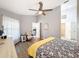 Spacious bedroom with ceiling fan, wood-look floors, light gray walls, and chair next to the window at 7518 Mediterranean Ct, Hudson, FL 34667