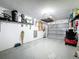 Spacious garage with ample storage on shelves, an electric garage door and an epoxy floor at 7518 Mediterranean Ct, Hudson, FL 34667