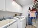 The laundry room offers a newer washer and dryer, storage cabinets, a sink, and a drying rack at 7518 Mediterranean Ct, Hudson, FL 34667
