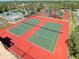 Enjoy a birds eye view of the community's two green tennis courts with a red perimeter fence at 7518 Mediterranean Ct, Hudson, FL 34667