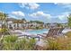 Beautiful community pool surrounded by palm trees, lounge chairs, and manicured landscaping at 8305 Crescent Oaks Dr, New Port Richey, FL 34655