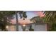 Charming home featuring unique architectural details, a well-manicured lawn, and mature trees at sunset at 8340 Saint Marks Ct, Hudson, FL 34667