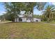 Inviting front of the home with a well-maintained lawn, mature trees and a long driveway at 8340 Saint Marks Ct, Hudson, FL 34667