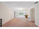 Spacious living room with a large window providing natural light and access to other rooms at 8340 Saint Marks Ct, Hudson, FL 34667