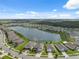 Panoramic aerial view showcases a vibrant community surrounding a serene lake with lush greenery and clear blue skies at 8938 Bower Bass Cir, Wesley Chapel, FL 33545