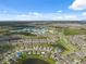 Wide aerial view of a community featuring houses surrounding ponds and lush green spaces at 8938 Bower Bass Cir, Wesley Chapel, FL 33545
