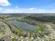 Breathtaking aerial view of a lakefront community, offering serene water views amidst lush greenery and suburban charm at 8938 Bower Bass Cir, Wesley Chapel, FL 33545