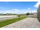 Lakeside backyard with a stone patio, grassy area, and fencing for privacy at 8938 Bower Bass Cir, Wesley Chapel, FL 33545