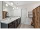 Bright bathroom features a double vanity, large mirror and modern lighting fixtures at 8938 Bower Bass Cir, Wesley Chapel, FL 33545