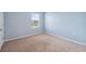 A carpeted bedroom with blue walls features a window and ample natural light at 8938 Bower Bass Cir, Wesley Chapel, FL 33545