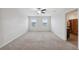 Expansive carpeted bedroom with two sunny windows, neutral paint, and ceiling fan at 8938 Bower Bass Cir, Wesley Chapel, FL 33545