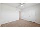 Neutral carpeted bedroom offers a ceiling fan and a closet for storage at 8938 Bower Bass Cir, Wesley Chapel, FL 33545