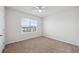 Bright bedroom features a ceiling fan, a window with blinds, and neutral carpet at 8938 Bower Bass Cir, Wesley Chapel, FL 33545