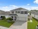 Charming two-story home featuring a well-manicured lawn, complemented by neutral tones and dark shutters at 8938 Bower Bass Cir, Wesley Chapel, FL 33545