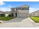 Inviting two-story home with well-maintained lawn, two-car garage, and classic black shutters. Large driveway at 8938 Bower Bass Cir, Wesley Chapel, FL 33545