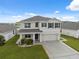 Charming two-story home with a well-manicured lawn, complemented by neutral tones and dark shutters at 8938 Bower Bass Cir, Wesley Chapel, FL 33545
