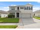 Inviting two-story home with well-maintained lawn, two-car garage, and classic black shutters at 8938 Bower Bass Cir, Wesley Chapel, FL 33545