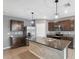 Open concept kitchen with stainless steel appliances, granite countertops, large island, and brown cabinets at 8938 Bower Bass Cir, Wesley Chapel, FL 33545