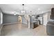 Open concept living room and eat-in kitchen area with tile floors, brown cabinets, and stainless steel appliances at 8938 Bower Bass Cir, Wesley Chapel, FL 33545