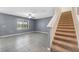 Open-concept living area with tile floors, staircase, and a view from the window at 8938 Bower Bass Cir, Wesley Chapel, FL 33545