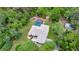 Lovely aerial view of home with screened-in pool, complemented by mature trees and verdant landscaping at 9130 Madrid Rd, Weeki Wachee, FL 34613