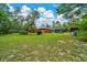 Expansive backyard featuring a screened-in pool and lush greenery at 9130 Madrid Rd, Weeki Wachee, FL 34613