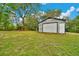 Backyard featuring a storage shed and a pergola, set against a backdrop of lush greenery and trees at 9130 Madrid Rd, Weeki Wachee, FL 34613