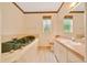 Bathroom featuring a jetted tub with tile surround, vanity, and toilet at 9130 Madrid Rd, Weeki Wachee, FL 34613