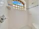 Bright white tiled shower featuring a glass block window and a built-in bench at 9130 Madrid Rd, Weeki Wachee, FL 34613