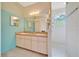 Bathroom features a double sink vanity, large mirror, and natural light from window in shower at 9130 Madrid Rd, Weeki Wachee, FL 34613
