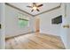 Bedroom features light wood floors, ceiling fan and a window that brings in natural light at 9130 Madrid Rd, Weeki Wachee, FL 34613