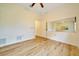 Bedroom features light wood floors, ceiling fan, and a mirror at 9130 Madrid Rd, Weeki Wachee, FL 34613