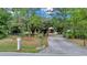 Exterior view of the house from the street, showing the long driveway and mature trees lining the property at 9130 Madrid Rd, Weeki Wachee, FL 34613