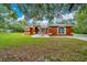 Charming single-story home featuring a well-manicured lawn, arched windows, and a welcoming front entry at 9130 Madrid Rd, Weeki Wachee, FL 34613