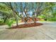 Landscaped front yard featuring mature trees, mulch beds, and a driveway leading to a home at 9130 Madrid Rd, Weeki Wachee, FL 34613