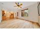 Open-concept living room has wood-look floors, ceiling fan, and eat-in kitchen access at 9130 Madrid Rd, Weeki Wachee, FL 34613