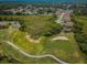 Aerial view of a community golf course, ponds, lush landscaping, and single-Gathering homes on a sunny day at 9719 Oakwood Hills Ct, New Port Richey, FL 34655