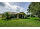 The backyard has a lush green lawn and mature trees with a screened in lanai at 9719 Oakwood Hills Ct, New Port Richey, FL 34655
