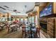 Inviting dining area with fireplace, multiple tables, and TV for a relaxing and enjoyable experience at 9719 Oakwood Hills Ct, New Port Richey, FL 34655