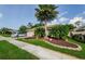 Well-maintained home featuring mature palm trees, green lawn, and a charming, landscaped front yard at 9719 Oakwood Hills Ct, New Port Richey, FL 34655