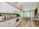 Well-equipped kitchen featuring white cabinetry, updated appliances, and a cozy breakfast nook at 9719 Oakwood Hills Ct, New Port Richey, FL 34655
