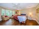 Cozy main bedroom with hardwood floors, large windows, and a ceiling fan at 9719 Oakwood Hills Ct, New Port Richey, FL 34655