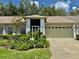 Charming single Gathering home showcasing lush landscaping and an attached two-car garage with a brick-paved driveway at 18142 Baywood Forest Dr, Hudson, FL 34667