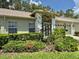Landscaped front yard with mature trees and white brick home at 18142 Baywood Forest Dr, Hudson, FL 34667
