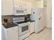 Kitchen with white appliances, granite countertops, tiled backsplash, and modern fixtures at 18142 Baywood Forest Dr, Hudson, FL 34667