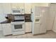 Kitchen with white appliances, granite countertops, and tiled backsplash at 18142 Baywood Forest Dr, Hudson, FL 34667