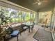 Relaxing screened patio with outdoor seating and view of landscaped backyard with mature trees at 18142 Baywood Forest Dr, Hudson, FL 34667